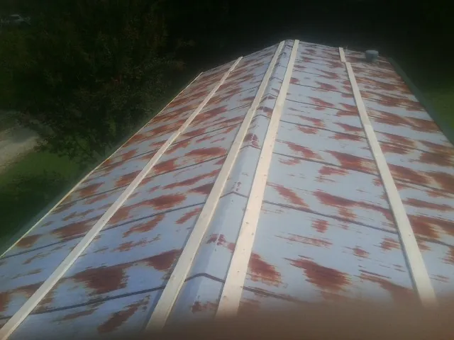 Rusted metal roof panels with new wood purlins before replacement — Storm Damage Roof Repair in Abrams by Roofing Brothers