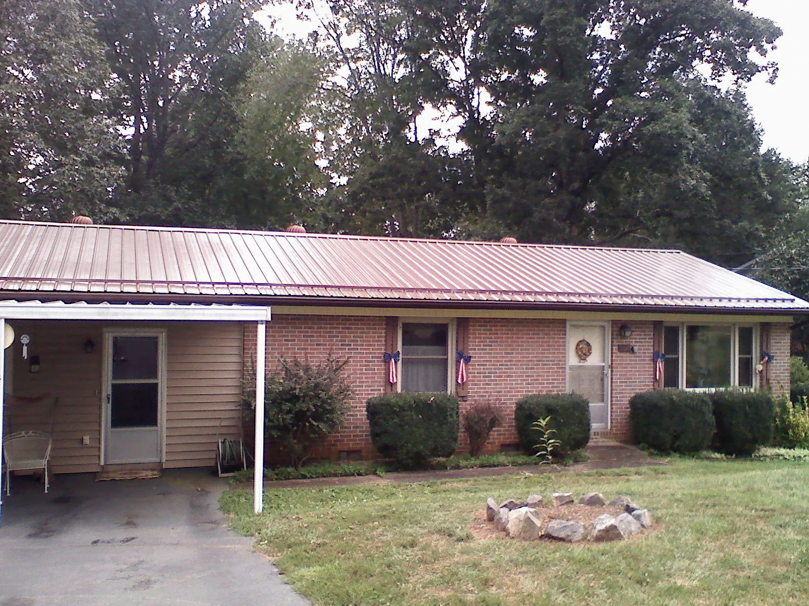 Bronze metal roof and carport on a brick ranch home — Roof Repair work by our crew in Abrams